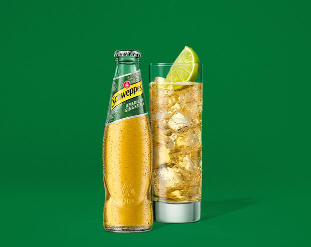 Schweppes American Ginger Ale – gekühlte 0,2-l Glasflasche mit Kondensperlen auf grünem Hintergrund.