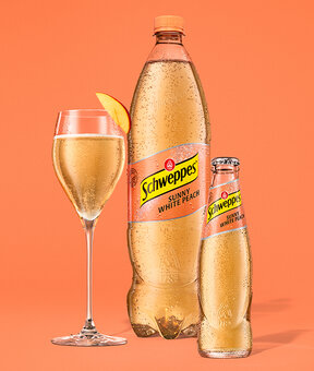 Schweppes White Peach – Glasflasche neben 1,25-l Flasche, beide mit Kondensperlen.